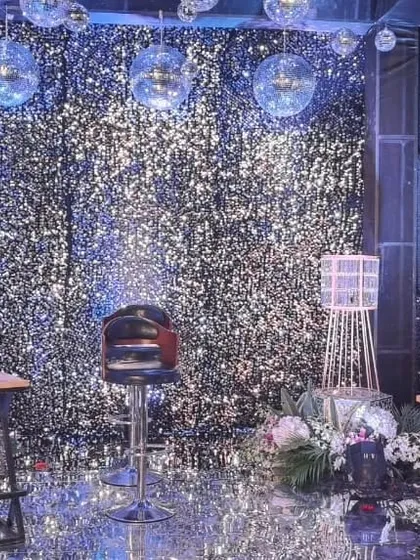 For a full glam effect, I can create a space covered in silver glitter panels and disco balls. This setup transforms any room into a dazzling party zone, ideal for milestone birthdays or disco themes.