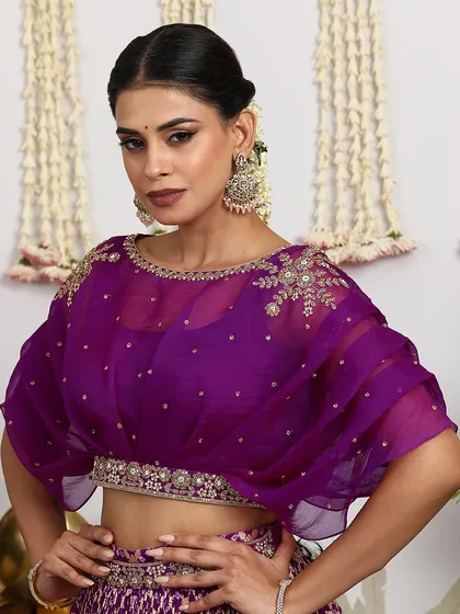 A close-up of the purple organza cape blouse, featuring delicate embroidery on the shoulders.
