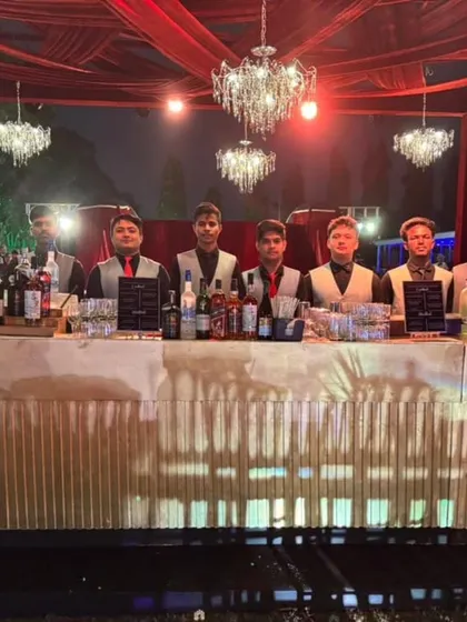 We set up stylish bars that match the elegance of your event. This beautiful gold shimmer bar, set under sparkling chandeliers, was the highlight of a sophisticated outdoor wedding reception, providing a glamorous spot for guests to gather.
