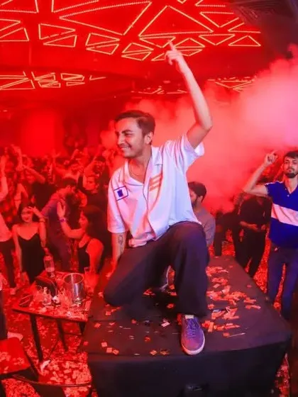 On top of the console, surrounded by red lights and smoke effects. I don't just play music; I perform and create a spectacle that elevates the entire party.
