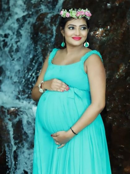 Set against a waterfall, this aqua maternity gown and floral crown create a beautiful, natural, and refreshing portrait for an expectant mother.
