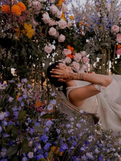 A beautiful, candid moment of the bride surrounded by flowers. The colors and natural beauty of the decor reflect the artistic and floral elements we wove into her invitation suite.