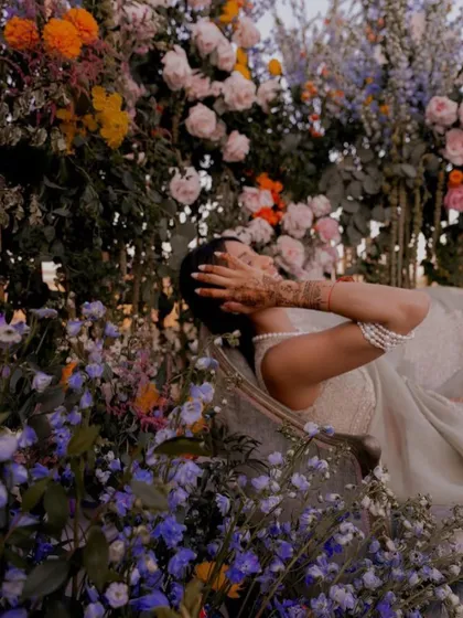 A beautiful, candid moment of the bride surrounded by flowers. The colors and natural beauty of the decor reflect the artistic and floral elements we wove into her invitation suite.