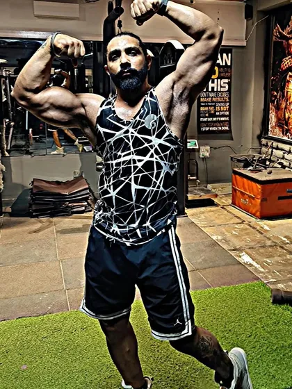 Defying limits and embracing strength. An athlete showing his classic physique pose in the gym, a testament to his hard work and our guidance.