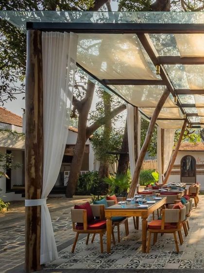 An elegant outdoor dining setup at Sanctuary Bar, with sheer white curtains creating a soft, romantic atmosphere under a canopy.
