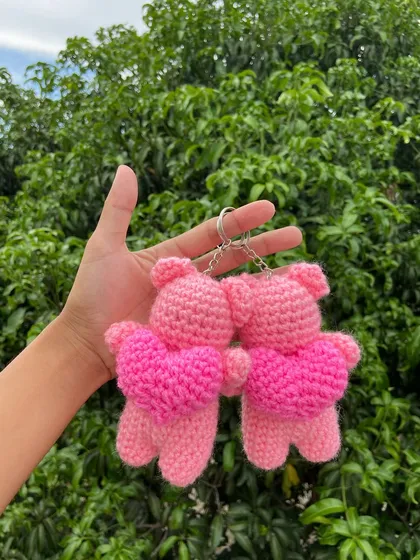 A pair of adorable pink bear keychains, each holding a bright pink heart. This is a popular design for gifts and special occasions.