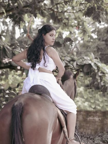 A female warrior concept shoot. These images showcase dynamic action poses, including mid-air shots with a bow and arrow, and serene moments with a horse, all set against a dramatic, smoky backdrop.
