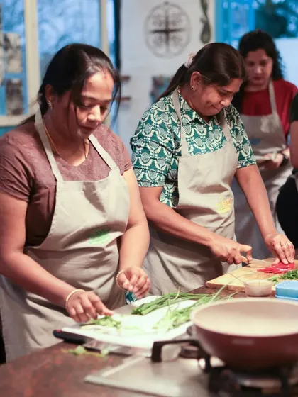 Teamwork in the kitchen. Participants in our Chinese Cuisine Masterclass work together, chopping fresh vegetables and preparing for the next step.