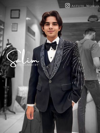 A young client wearing a three-piece tuxedo with abstract silver embroidery on the lapel and shoulder. This is a sophisticated look for a formal family occasion.