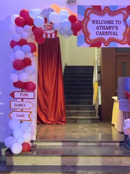 Welcome to the carnival. This fun and colorful first birthday theme features a classic red and white circus tent entrance, popcorn details, and a cute elephant prop.