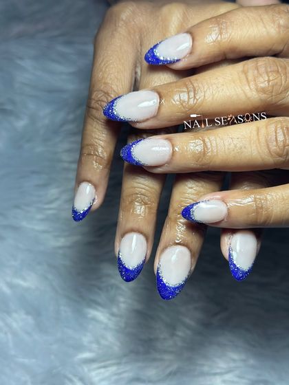 A classic French manicure with a bold, royal blue glitter tip.