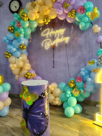 Another perspective of the pastel butterfly-themed birthday, highlighting the light-up number and balloon column.