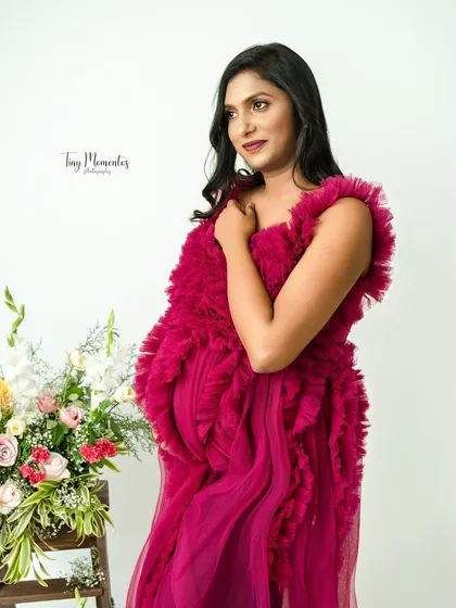 The vibrant magenta of this textured gown makes a bold and beautiful statement, celebrating the life and energy of motherhood.