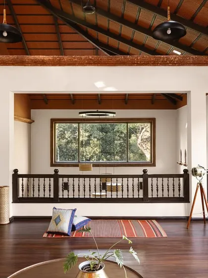 The mezzanine lounge offers a different perspective, looking out over the main living area. The design uses open railings and connected volumes to ensure that even separate spaces feel part of a cohesive, flowing whole, encouraging connection.