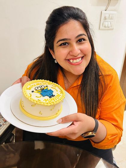 Our lovely client holding her 'One in a Minion' cake. We love seeing the joy our custom creations bring to your celebrations.