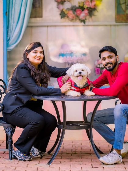 A happy family portrait, with the couple and their adorable dog posing at our cafe-style set.