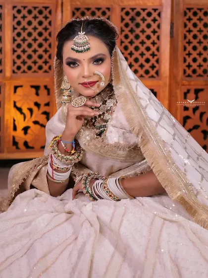 A beautiful seated portrait, with the bride's hand gently touching her chin, creating a thoughtful and elegant pose.