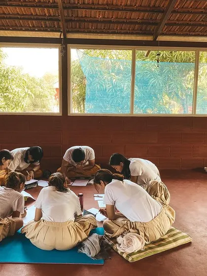 Students gather in a circle for a study session. The learning here is not just from books, but from shared discussion, reflection, and the collective energy of the group.