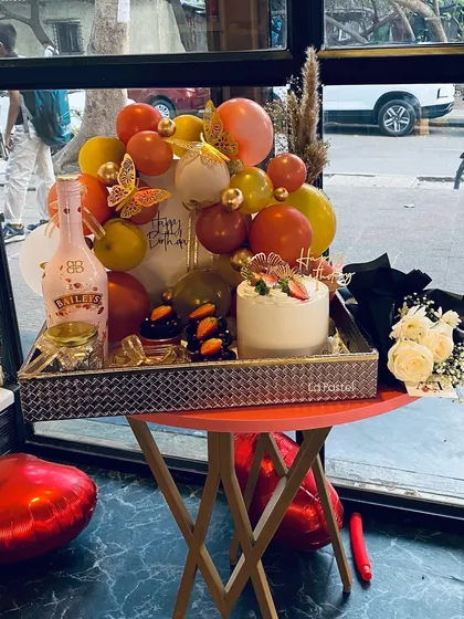 I love creating over-the-top birthday hampers. This one includes a custom cake, a bottle of Bailey's, chocolate treats, a balloon arrangement, and fresh flowers for a full party on a tray.
