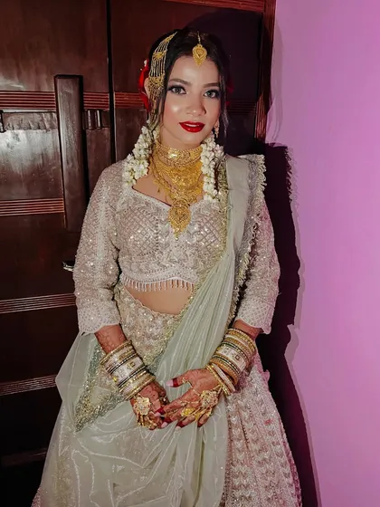 A full-length view of the Nikah bride in her beautiful white and gold lehenga.