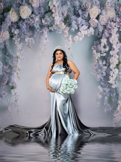 A regal solo portrait against a backdrop of cascading purple wisteria. The silver-blue satin gown and water reflection effect add a touch of magic and fantasy.