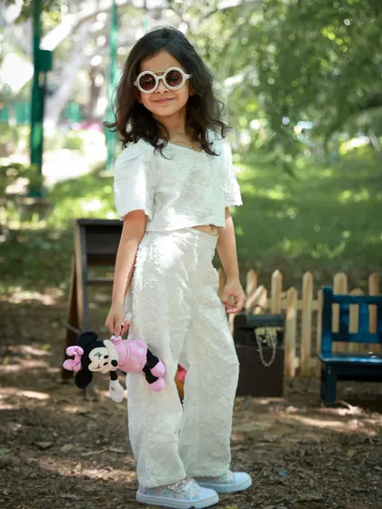 This little fashionista is striking a pose in the park, complete with cool sunglasses and a toy. Our outdoor shoots are perfect for capturing your child's unique style and personality.