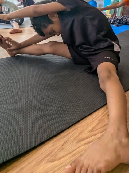 A young student demonstrates great form in a side stretch. We teach the importance of flexibility for dancers of all ages.