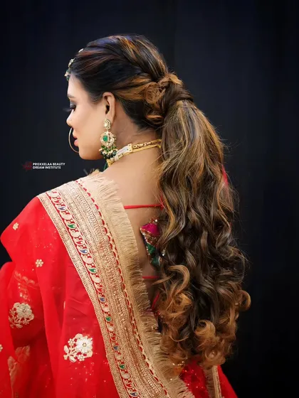 Embracing tradition with a modern twist. This hairstyle combines soft curls with a stylish ponytail, perfect for complementing a traditional Indian outfit.