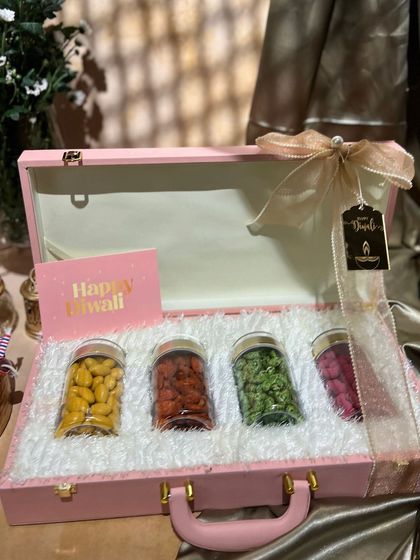 This pink suitcase-style box is a sweet and stylish option for Diwali. Lined with faux fur, it holds four jars of colorful dry fruits.