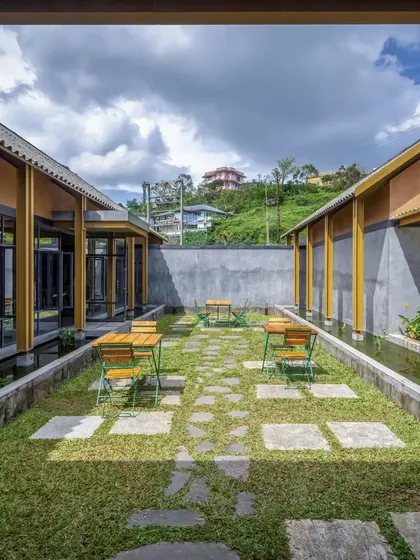 An intimate courtyard at the Teyla tea experience centre in Kerala. We designed this green space with stone slab pathways and surrounding water channels to feel like a modern 'chaithela', an honest and welcoming place for conversation.