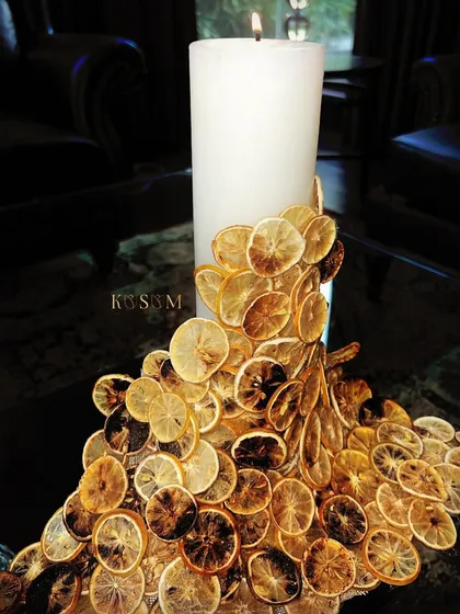 Where old meets new. This unique floral sculpture features a candle adorned with a cascade of dried lemon slices, creating a beautiful play of light, texture, and fragrance.