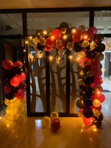 This birthday party decoration combines bold red, black, and gold balloons to create a dramatic and festive arch. I added fairy lights to the arrangement to give it a warm glow, making the celebration feel extra special after dark.