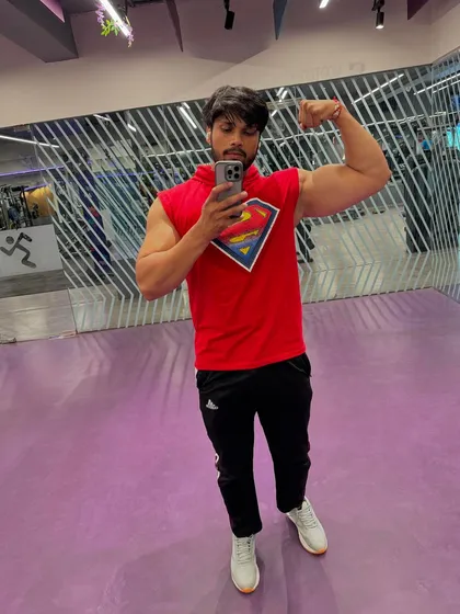 A mirror selfie showing a bicep flex.
