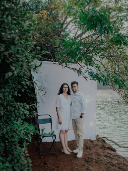 A creative outdoor setup using a simple white backdrop by the lake. This blends a studio look with the beauty of a natural location for a unique pre-wedding photo.