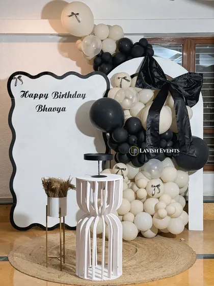 A close-up of the custom backdrop and balloon arrangement for the bow-themed party.
