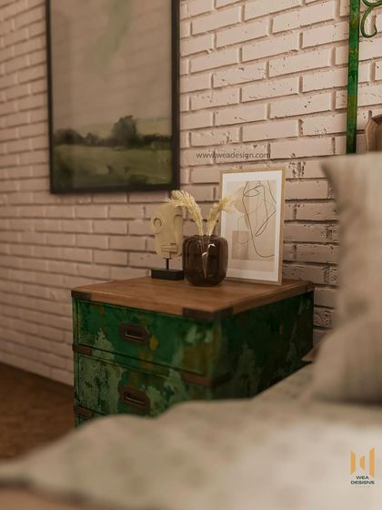 A close-up of the distressed green bedside table, which adds a pop of color and vintage character to the room.