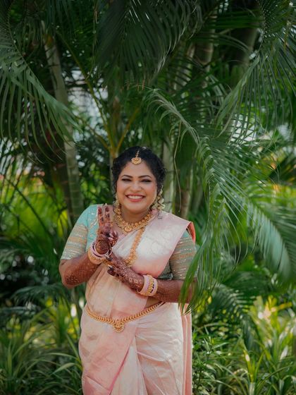 Another joyful portrait of the South Indian bride, smiling brightly and making a peace sign. Her happiness is infectious in this candid engagement photo.