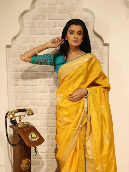 A styled shoot with a beautiful yellow saree. The makeup is kept minimal to let the vibrant color of the saree shine.