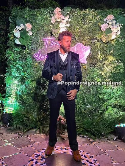 A client looking dapper in a black patterned three-piece suit. This is a perfect choice for an evening reception, offering a subtle texture that catches the light beautifully.