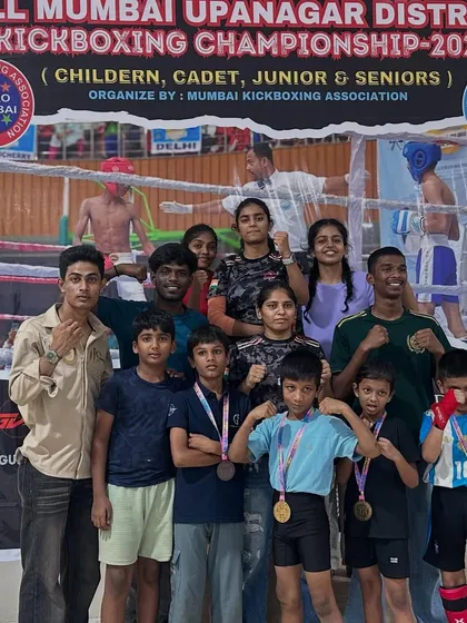 The whole team, including senior athletes and coaches, celebrating a massive victory at the All Mumbai Kickboxing Championship. It takes a village to raise a champion.