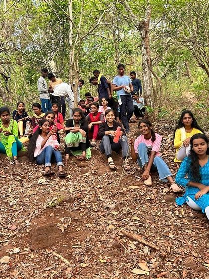 A group of campers rests on a trail during a trek at our Dandeli camp, surrounded by the forest.