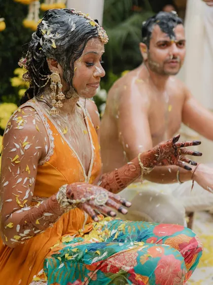 Even when things get messy, a bride should still feel beautiful. This shot captures the playful reality of a Haldi ceremony, and her outfit held up beautifully through it all.