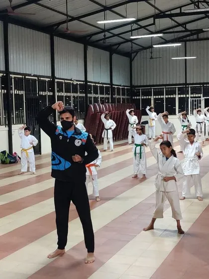 Discipline in action. A class of young students practices fundamental blocking techniques in unison, learning the focus and precision that are core to karate.
