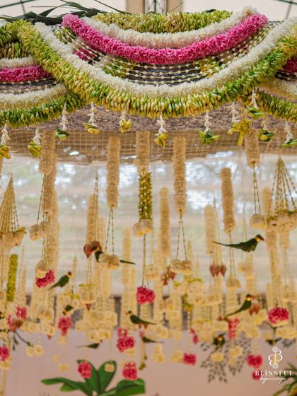 An overhead view of the intricate floral ceiling of the mandap. We used garlands of jasmine and tuberoses, interspersed with small parrot figures, to create a fragrant and beautiful canopy.