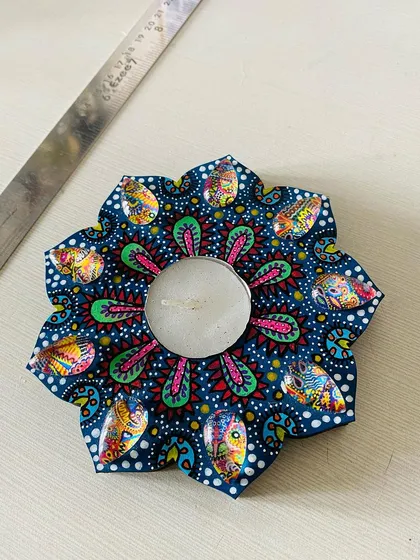 A dark blue floral candle holder with vibrant pink and green details. The contrast makes the colors pop, especially in low light.