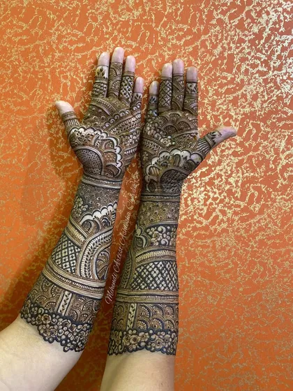 A full-arm mehendi design with intricate patterns. The design is dense and beautiful, perfect for a bride who wants a classic look.