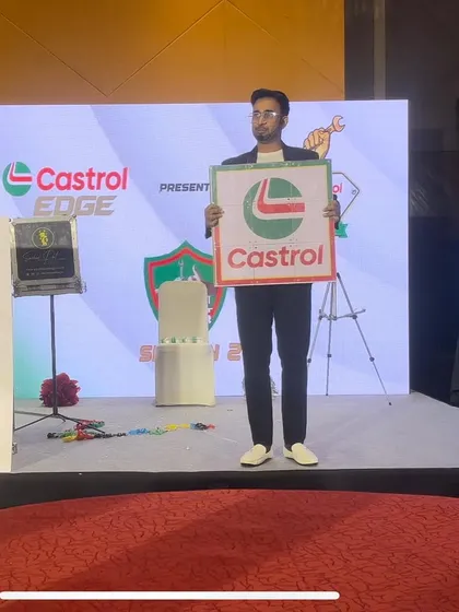 Holding up the Castrol logo after magically producing it during their "Ustaadon ka Ustaad" event. It's a powerful visual that reinforces the brand message.