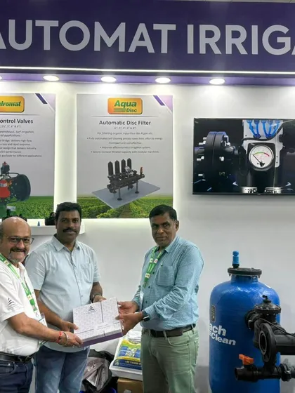 Our team presenting a token of appreciation to a valued partner at our Agri Intex booth, surrounded by our product displays for automatic disc filters and control valves.