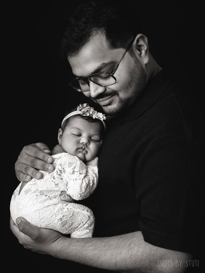 A father's gentle hold. This black and white portrait is full of emotion and tenderness.