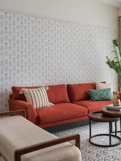 This side of the 'Living life in Colour' living room features a vibrant wine-colored sofa set against an arched niche with character-rich wallpaper.